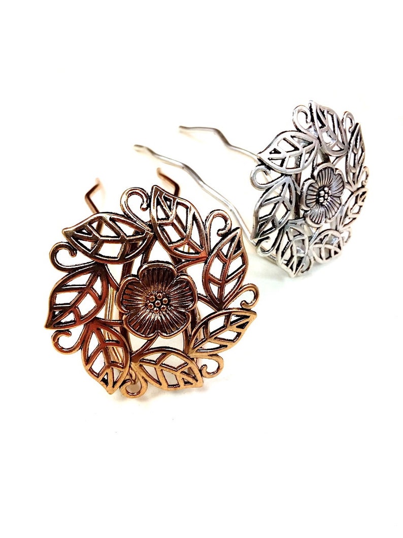 Pu&ograve; includere: Due fermagli per capelli con un design floreale. Un fermaglio &egrave; dorato e l'altro &egrave; argentato. Il design floreale presenta un fiore con foglie.