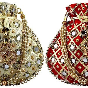 May include: Two ornate drawstring bags with mirror embellishments. One bag is gold with a white lining and the other is red with a white lining. Both bags have a gold chain strap and a tassel.