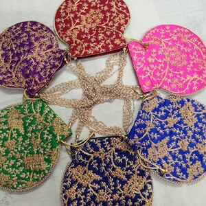 May include: Six round, embroidered fabric purses with gold thread and pearl embellishments. The purses are in various colors, including purple, red, pink, green, and blue.