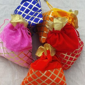 May include: Five small drawstring bags made of velvet with gold and colored patterned designs. The bags are pink, red, orange, yellow, and blue.