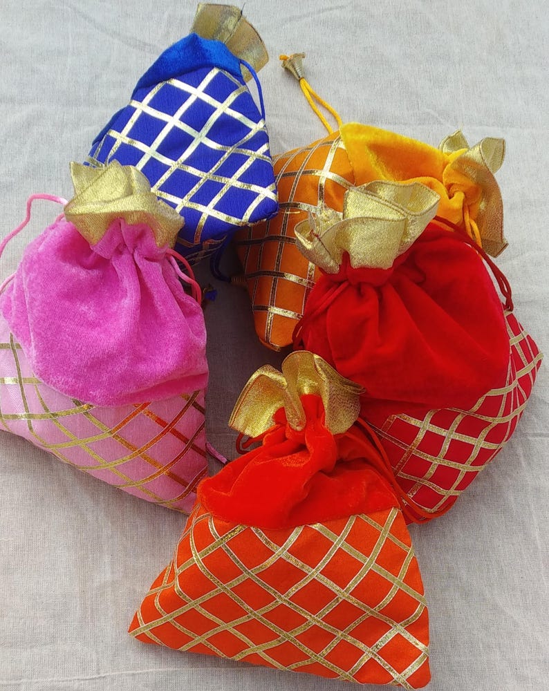 May include: Five small drawstring bags made of velvet with gold and colored patterned designs. The bags are pink, red, orange, yellow, and blue.