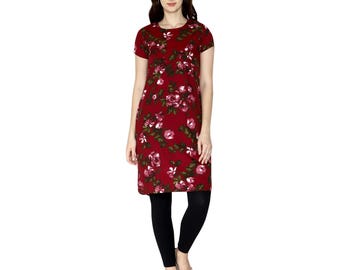 Puede incluir: Un vestido túnica burdeos con un estampado floral de rosas rosas y blancas y hojas verdes. El vestido tiene mangas cortas y un dobladillo hasta la rodilla. La persona lleva leggings negros y sandalias doradas.