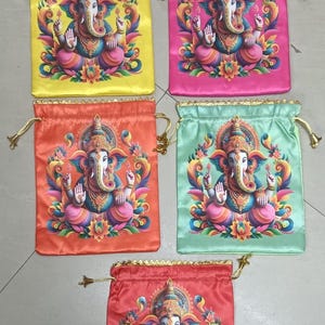 May include: Five colorful drawstring bags, each featuring a vibrant illustration of the Hindu deity Ganesha. The bags are in shades of yellow, pink, orange, green, and red, with gold-colored drawstrings.