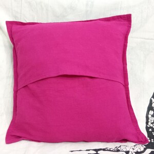 May include: A bright pink pillow with a hidden zipper closure on the back. The pillow is made of a soft, cotton fabric.