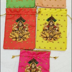 Puede incluir: Una colección de bolsas con cordón en varios colores, incluyendo verde, melocotón, rojo, amarillo y rosa. Cada bolsa presenta una ilustración detallada de una deidad sentada en una flor de loto. Las bolsas están adornadas con cordones dorados.