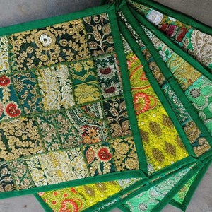 Puede incluir: Conjunto de seis posavasos de tela verde con diseños de patchwork bordados de colores. Los posavasos tienen un borde verde y están hechos de una variedad de telas.