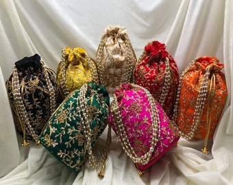 May include: Seven drawstring bags with pearl embellishments. The bags are in various colors, including black, green, yellow, white, red, pink, and orange. Each bag has a gold embroidered design.