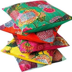 May include: A stack of five colorful patterned throw pillows with floral designs. The pillows are made of fabric and have a quilted texture.