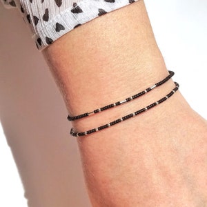 Thin miyuki stretch bracelet of tiny rocaille beads in black and silver color, minimalist style, light, seed beads