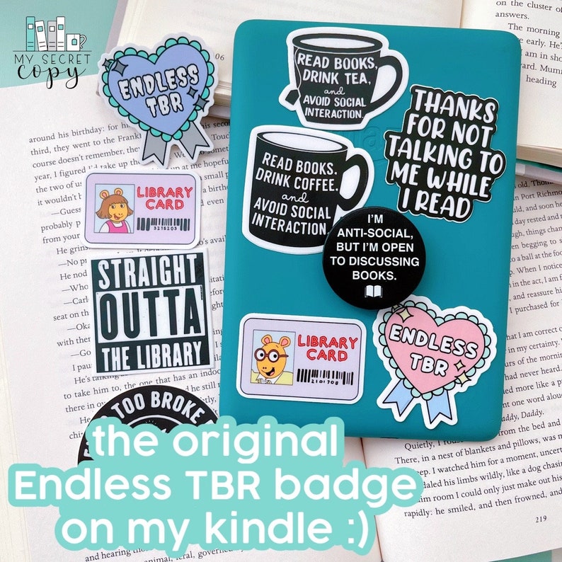May include: A teal blue notebook with various stickers on it. The stickers are mostly black and white with text that reads "Read Books, Drink Tea, and Avoid Social Interaction", "Read Books, Drink Coffee, and Avoid Social Interaction", "I'm Anti-Social, But I'm Open to Discussing Books", "Thanks for Not Talking to Me While I Read", "Straight Outta the Library", "Library Card", "Endless TBR", and "Endless TBR".