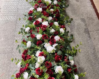Arco de flores artificiais de eucalipto bordô para casamento, ideal para o cenário da cerimônia.