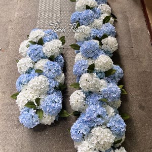 Könnte beinhalten: Arrangement aus künstlichen Hortensienblüten in Blau und Weiß, mit grünen Blättern. Die Blumen sind in einer länglichen, rechteckigen Form angeordnet, ideal für dekorative Zwecke. Der Text "James Flower" ist sichtbar.