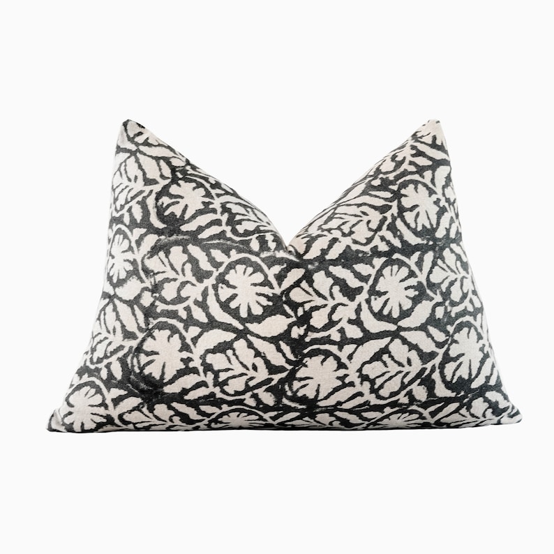 May include: Black and white patterned throw pillow with a floral design.