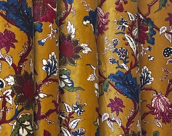Könnte beinhalten: Senffarbener Stoff mit floralem Muster. Das Design zeigt große, stilisierte Blumen in Burgunder-, Blau- und Weißtönen, vor dem Hintergrund von sich windenden Ästen. Der Stoff hat eine weiche, samtige Textur, und das Muster wiederholt sich über die gesamte Oberfläche.
