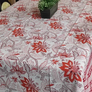 May include: White tablecloth with a red floral pattern. The tablecloth has a border of red and white.