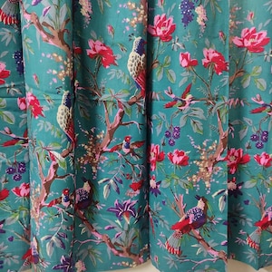 Puede incluir: Tela color turquesa con un patr&oacute;n repetido de p&aacute;jaros, flores y ramas. Los p&aacute;jaros son multicolores, y las flores son rosas y moradas. Las ramas son marrones y las hojas son verdes. Adecuado para cortinas o tapicer&iacute;a.