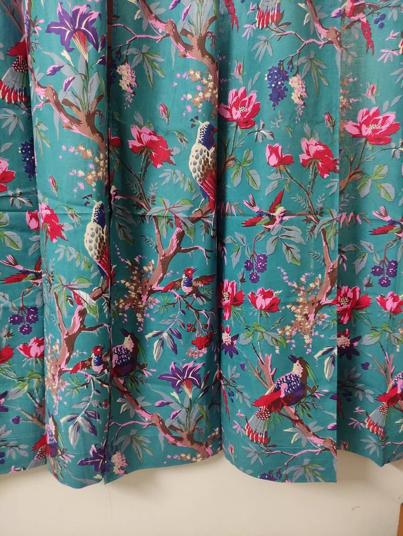 Puede incluir: Tela color turquesa con un patr&oacute;n repetido de p&aacute;jaros, flores y ramas. Los p&aacute;jaros son multicolores, y las flores son rosas y moradas. Las ramas son marrones y las hojas son verdes. Adecuado para cortinas o tapicer&iacute;a.