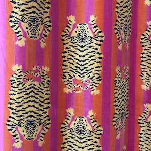 May include: A fabric featuring a repeating pattern of yellow and black tigers arranged in vertical columns. The tigers are set against a background of alternating vertical stripes in vibrant shades of hot pink and bright orange throughout the textile.