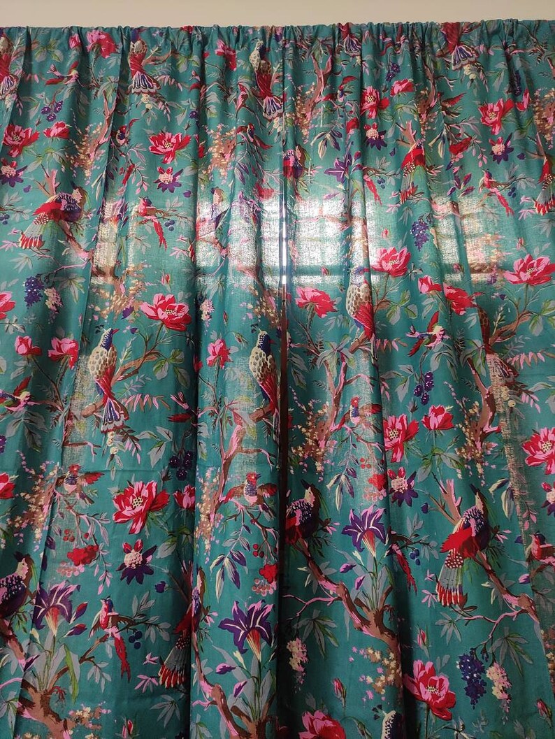 Puede incluir: Paneles de cortina de color turquesa con un vibrante estampado floral y de p&aacute;jaros. El dise&ntilde;o presenta flores rojas, acentos morados e ilustraciones detalladas de p&aacute;jaros posados en ramas. La tela es semitransparente.