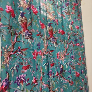 Puede incluir: Panel de cortina de color turquesa con un estampado floral y de aves vibrante. El dise&ntilde;o presenta flores rojas, rosas y moradas, junto con ilustraciones detalladas de aves posadas en ramas. La cortina es de tela ligera.