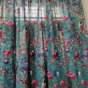 Puede incluir: Panel de cortina de color turquesa con un patr&oacute;n repetido de p&aacute;jaros, flores y ramas. El dise&ntilde;o presenta elementos florales rojos, rosas, morados y blancos, con p&aacute;jaros posados en ramas marrones. La cortina es de tela ligera.