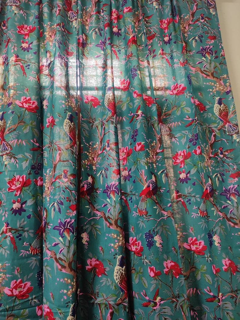 Puede incluir: Panel de cortina de color turquesa con un patr&oacute;n repetido de p&aacute;jaros, flores y ramas. El dise&ntilde;o presenta elementos florales rojos, rosas, morados y blancos, con p&aacute;jaros posados en ramas marrones. La cortina es de tela ligera.