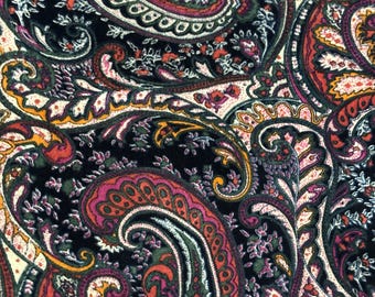 May include: A fabric featuring a dense, intricate paisley pattern with a black background. The design incorporates vibrant shades of magenta, orange, forest green, and cream, with detailed floral and teardrop motifs covering the entire surface.