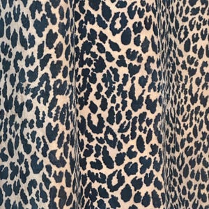 Op de afbeelding: Close-up van een stof met een luipaardprint in zwart en beige.