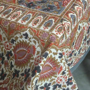 Può includere: Una tovaglia bianca con un motivo floreale in tonalità di marrone, rosso e grigio. Il motivo presenta dettagli intricati e un design di tipo paisley.