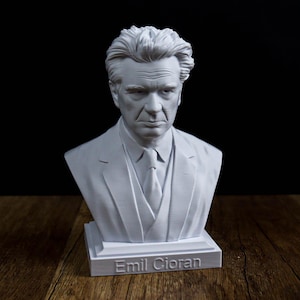 May include: A white 3D printed bust of Emil Cioran, featuring a detailed facial expression, wavy hair, and a suit with a tie. The base of the sculpture is rectangular and clearly displays the name Emil Cioran embossed in white capital letters.