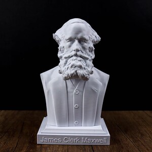 May include: A white bust of James Clerk Maxwell, featuring a detailed depiction of his face, beard, and suit. The bust is mounted on a rectangular base with the name "James Clerk Maxwell" inscribed on it. The background is dark.