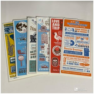 Könnte beinhalten: Eine Sammlung von Lesezeichen zum Thema Reisen mit verschiedenen Designs. Jedes Lesezeichen zeigt Illustrationen von Sehenswürdigkeiten, reisebezogenen Bildern und Text. Die Farbpalette umfasst Blau, Rot, Orange und Gelb, mit etwas Text auf Englisch.