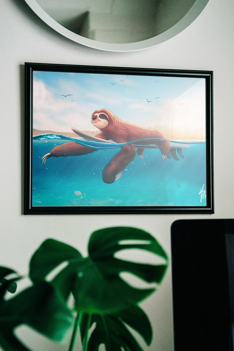 May include: A framed illustration of a brown sloth surfing on a surfboard in blue water with a blue sky and white clouds in the background.