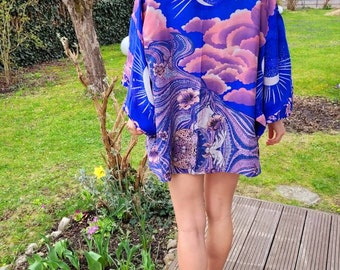 May include: A blue and pink kimono with a crescent moon and star design. The kimono is made of a silky fabric and has a relaxed fit.