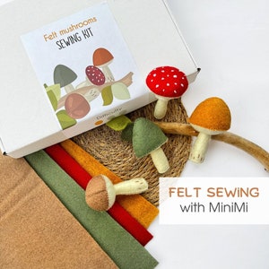 May include: A felt mushroom sewing kit featuring a white box with the text Felt mushrooms SEWING KIT, four finished felt mushrooms in red, orange, green, and brown, and stacked sheets of felt fabric in tan, green, red, and orange colors.