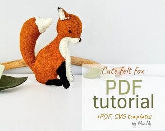 May include: A cute felt fox craft tutorial with PDF and SVG templates. The fox is orange with a white chest and black feet. The text reads "Cute felt fox PDF tutorial + PDF, SVG templates by MiniMi".