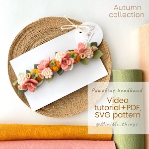 Könnte beinhalten: Ein Filz-Haarreif mit einer Reihe von orangefarbenen Kürbissen und rosa Blumen. Der Haarreif liegt auf einer weißen Karte mit dem Text "Pumpkins headband Video tutorial+PDF, SVG pattern @MiniMi-things".