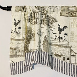 May include: A cream-colored valance with a farmhouse theme. The valance features a black and white striped bottom border and a printed design of a barn, a windmill, a rooster weather vane, and a sign that reads "Farm Fresh Produce Dairy Products".