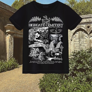 May include: Black t-shirt with a graphic print of Highgate Cemetery in London, England. The print features a black and white image of a cemetery with a statue of an angel and a tombstone with the text "Take me to Highgate Cemetery, Swan's Lane, London, N6, 1819".