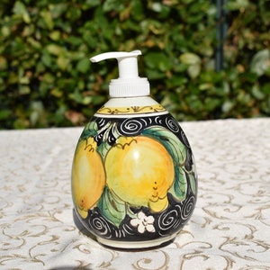 Può includere: Dispenser di sapone in ceramica con una pompa bianca e un design nero, giallo e verde con limoni.