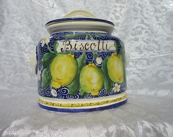 May include: Ceramic cookie jar with a blue and white design featuring lemons and the word "Biscotti".