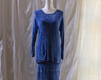 May include: A blue knit sweater and skirt set. The sweater has a long sleeve and a pocket on the front. The skirt is a maxi skirt.