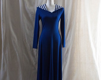 Puede incluir: Un vestido largo azul maxi con un cuello marinero de rayas blancas. El vestido tiene mangas largas y un corpiño ajustado.