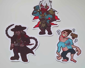 May include: Three illustrated stickers featuring a red and white demon warrior, a cowboy with a chain and a gun, and a man with a question mark above his head and a dog.