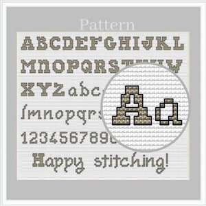May include: Cross-stitch pattern featuring the alphabet, numbers, and the phrase "Happy stitching!" in a serif font. The letters and numbers are in a tan color, and the background is white. The word "Pattern" is at the top.