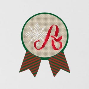 May include: A red letter A with a white snowflake in a green circle with red and green striped ribbon.