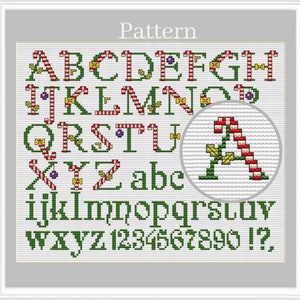 May include: Cross stitch pattern featuring a Christmas alphabet with candy cane and holly accents. The pattern includes uppercase and lowercase letters, numbers, and punctuation marks.