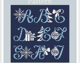 May include: Cross-stitch pattern with a navy blue background and light blue and white holiday-themed designs. The pattern includes letters, snowflakes, a Christmas tree, a gift, a bow, and an ornament. The word "Pattern" is at the top.