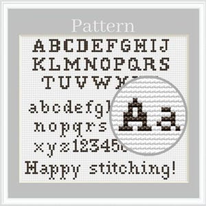 May include: Cross-stitch pattern with uppercase and lowercase letters, numbers, and the words "Happy stitching!" in black on a white background. A magnifying circle shows the detail of the stitching.