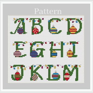 Puede incluir: Patrón de punto de cruz con las letras del alfabeto de la A a la M, cada una decorada con adornos navideños y luces de cadena. Las letras son verdes y los adornos son rojos, azules, amarillos y blancos. La palabra "Pattern" está en la parte superior.